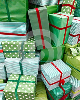 Closeup image of pile of lots of Christmas gifts. Stack of green boxes with red ribbons with New Year presents