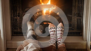 CLoseup image of romantic couple in woolen warm socks warming by the fire at house