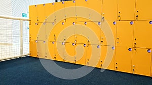 CLoseup image of straight long rows of yellow lockers in the school or college