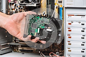 Closeup image of technician man hand changing the hard drive of pc computer . Maintenance and repair computer hardware