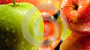 Closeup image of water droplets on green ripe apple lying on mirror surface. Abstract background of seasonal fruits