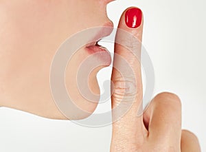 Closeup image of a woman gesturing quiet from side view isolated