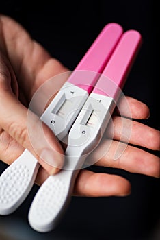 Closeup image of a woman hand holding home pregnancy tests