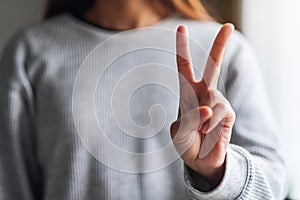 A woman making and showing number two hand sign