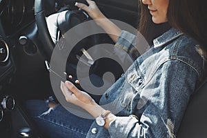 A woman using mobile phone while driving a car