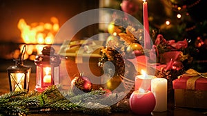 Closeup image of wooden table decorated for Christmas against burning fireplace at living room