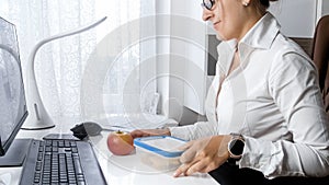 Closeup image of young female office worker taking out lunch box