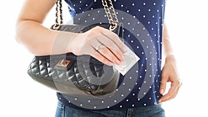 Closeup image of young woman holding condom in hand. Concept of contraception and safety in sex.