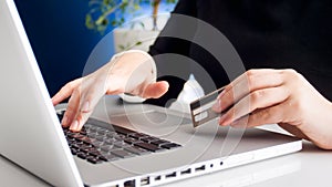 Closeup image of young woman shpping online holding plastic credit card photo