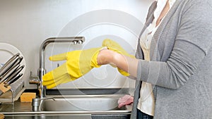 Closeup image of young woman wearing yellow protective gloves