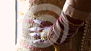 Closeup of an Indian brides hand adorned with traditional ceremonial jewlery and henna. 1080 24 FPS