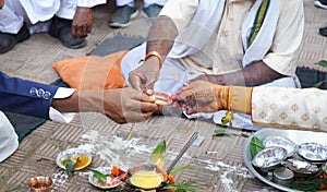 Closeup of Indian groom father and groom offering prayer during marriage.