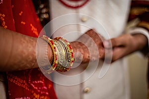 Closeup of Indian marriage couple hands with henna and jewelry