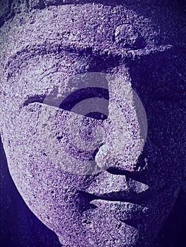 Closeup of Indian woman statue face with closed eyes and ultraviolet shadows