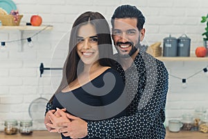 Closeup indoor portrait shot of two attractive people in a relationship. Young married couple standing in the kitchen