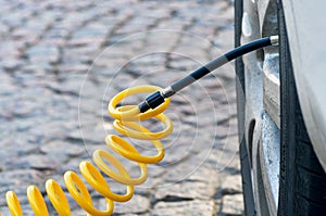 Closeup of inflating car tyre with electric pump.