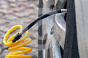 Closeup of inflating car tyre with electric pump