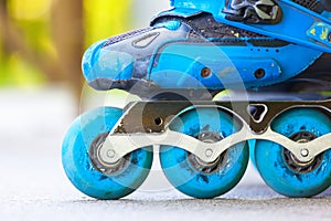 Closeup of inline roller skates with blue wheels.