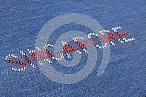 Closeup inscription Singapore, inlaid rhinestones on denim.