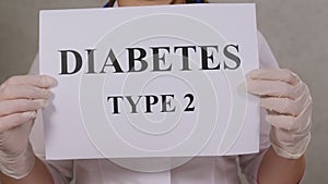 Closeup of the inscription TYPE 2 DIABETES on white paper in the hands of doctor