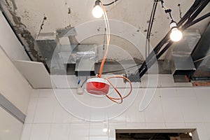 Closeup installation and repair of electric cable, smoke detector, fire alarm system before installing stretch or suspended