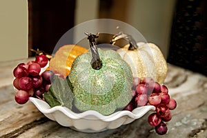 Closeup of Interior Kitchen counter with three Faux Decorative Pumpkins with grapes in bowl photo