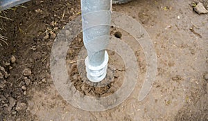 Closeup of iron support on a wooden pillar on the construction site with screw.