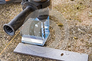 Closeup of iron support on a wooden pillar on the construction site with screw.