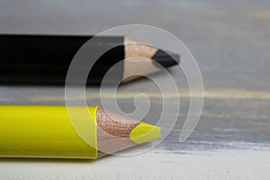 Closeup of isolated colorful yellow and black crayons on wood background - german parties FDP and CDU coalition concept