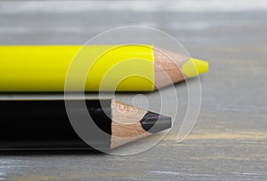 Closeup of isolated colorful yellow and black crayons on wood background - german parties FDP and CDU coalition concept photo
