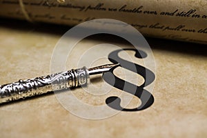 Closeup of isolated paragraph sign on ol vintage paper with silver retro ink pen and text document