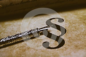 Closeup of isolated paragraph sign on ol vintage paper with silver retro ink pen and text document