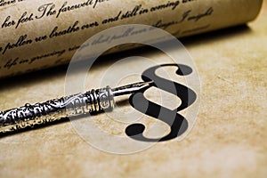 Closeup of isolated paragraph sign on ol vintage paper with silver retro ink pen and text document