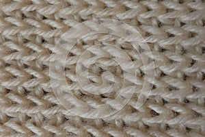 Closeup of ivory handmade knitted fabric ribbing pattern
