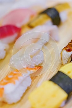 Closeup on Japanese ebi shrimp and tamagoyaki grilled egg sushi with other seafood pieces of rice hand-pressed nigirizushi