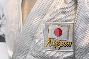 Closeup on a Japanese Judo uniform adorned with Japan national flag and word Nippon.