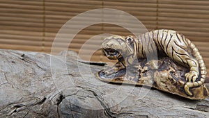 Closeup of japanese netsuke figure on wood and bamboo background. Statue tiger mascot