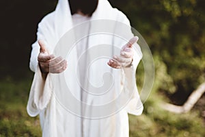 Closeup of Jesus Christ reaching out with a blurred background photo