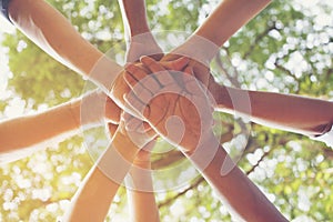 Closeup  joining hands together, shot against  background