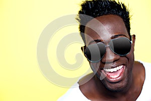 Closeup of joyful young african guy in sunglasses