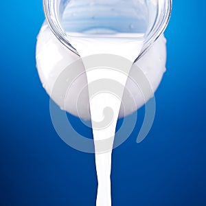 Closeup of a jug with pouring milk