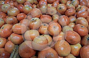 Closeup of juicy ripe orange tangerines (citrus reticula) at the market good as a background photo