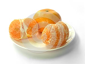 Closeup of juicy ripe orange tangerines (citrus reticula) peeled on a plate with a white background photo