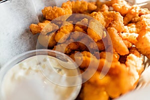 Closeup of Karaage with a white sauce under the lights with a blurry background