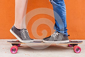 Closeup kissing couple at skateboard and red wall background