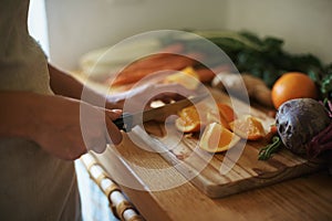 Closeup, kitchen and fruits with woman, vegetables and chopping board with knife and salad. Person, vegan and chef with