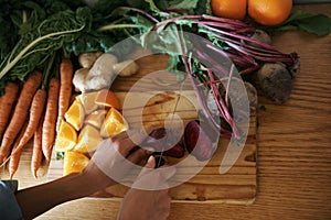 Closeup, kitchen and hands with woman, vegetables and chopping board with knife, home and diet plan. Person, vegan and