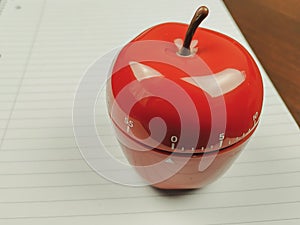 Closeup of kitchen timer in apple shape as a pomodoro study technique for schools for timing study sessions and beating