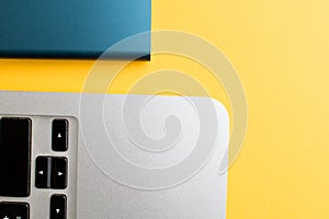 Closeup of a laptop edge and a hard drive on yellow background