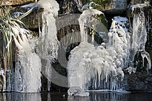 Frozen icicles hanging from waterfall in winter